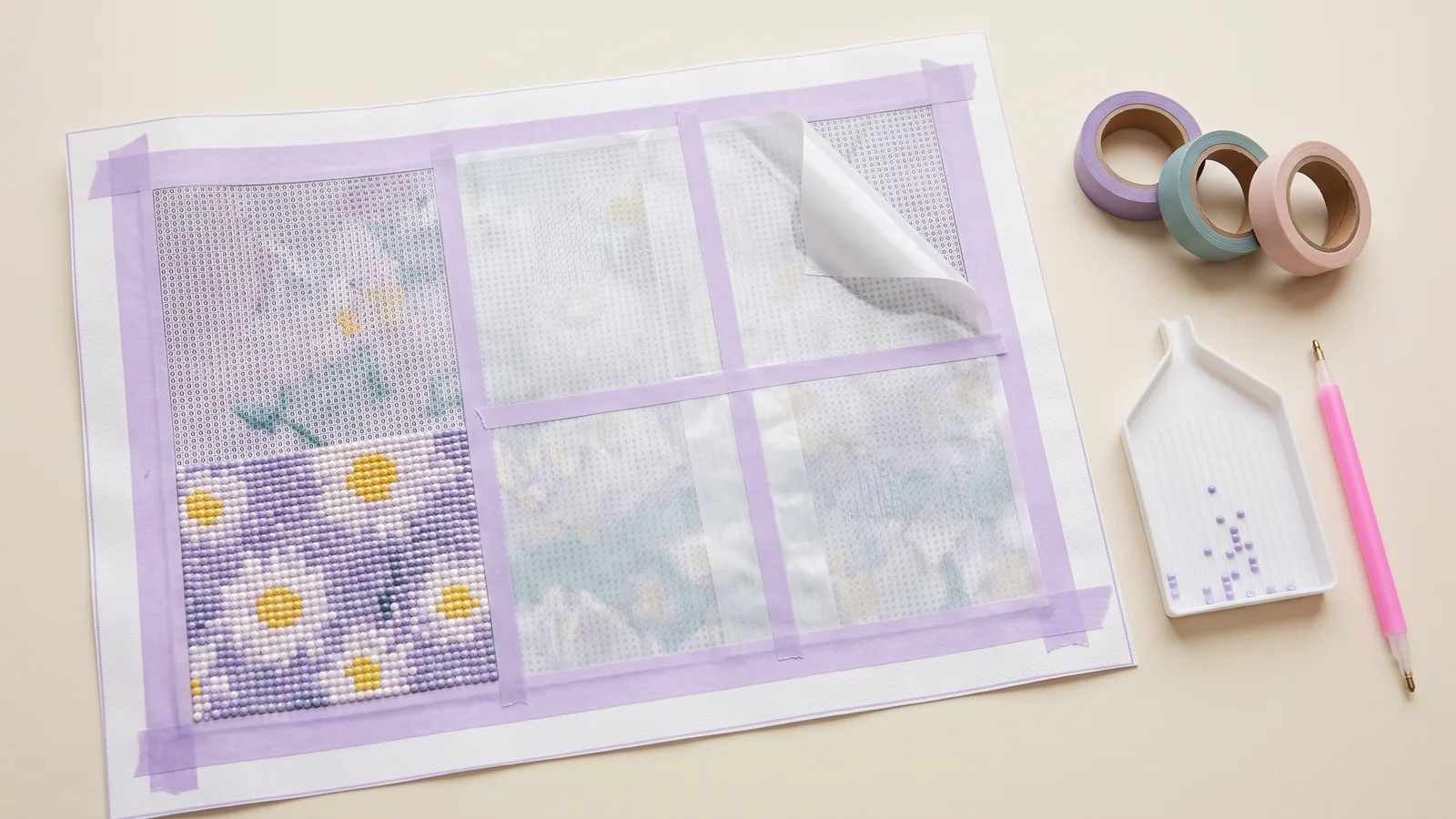 Lavender washi tape around a daisy diamond painting, with section guides, tape rolls, a tray, and an applicator pen.